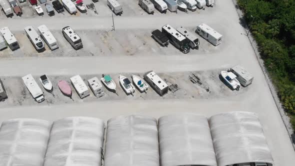 Forward drone aerial over boat and camper storage lot in South Florida.  Covered storage visible bel