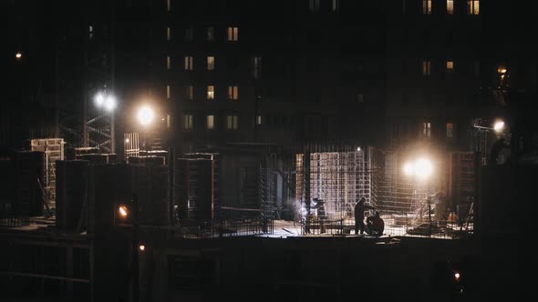 Construction Site Residential Building, Welding Instrument Workers Construct at Winter Night