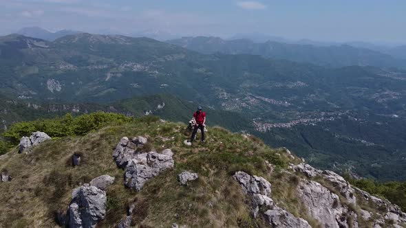 Hiker on top of mountain peak, European Alps, Lecco, Italy