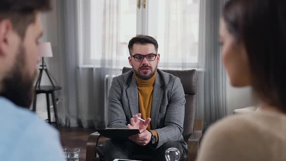 Couple Listening the Recommendations from Confident Professional Bearded Psychologist