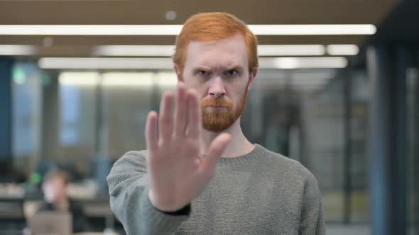 Portrait of Young Man Showing Stop Sign By Hand