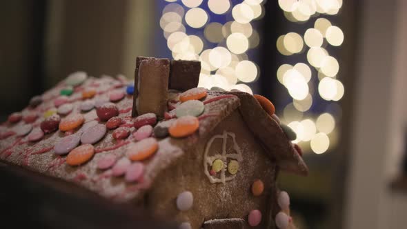 Close-up pan of upper half of gingerbread house with smarties on roof