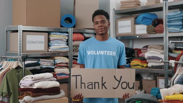 Portrait View of the Multiracial Volunteer Man Holding Banner with Thank you Phrase and Looking at
