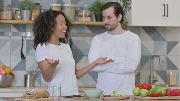 Young African Woman Arguing with Young Man in Kitchen