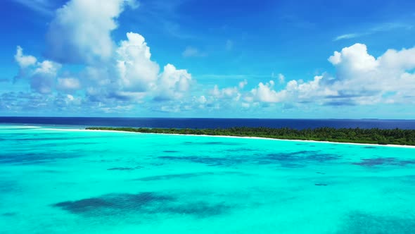 Aerial drone view scenery of idyllic shore beach voyage by aqua blue lagoon and bright sandy backgro