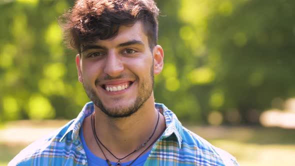 Portrait of Smiling Young Man in Summer Park 
