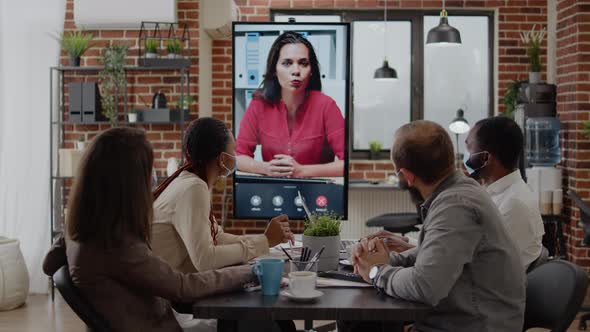 Colleagues Meeting with Woman on Video Call Conference