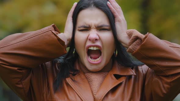 Portrait Annoyed Young Hispanic Woman Outdoors Screaming Loudly in Rage Madly Opening Mouth Holding