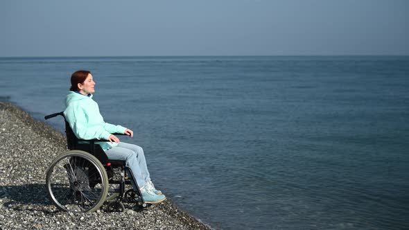 Pacified Caucasian Woman in a Wheelchair on the Seashore