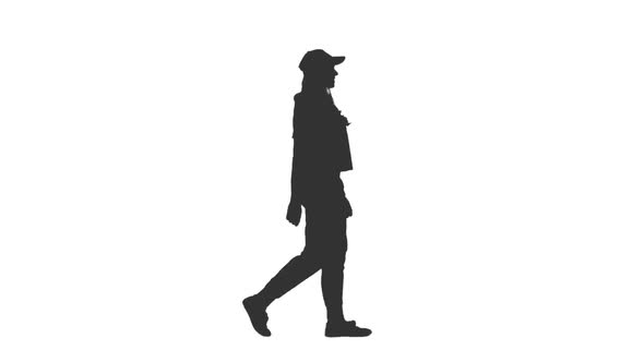 Silhouette of Young Woman Walking in Sportswear and Baseball Cap