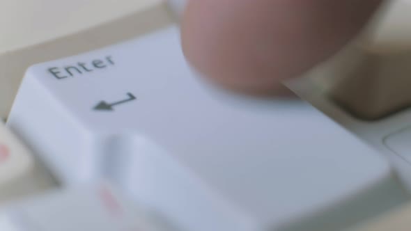 Close-up Shoot of Human Finger Repeatedly Pressing the Enter Key on a Keyboard.