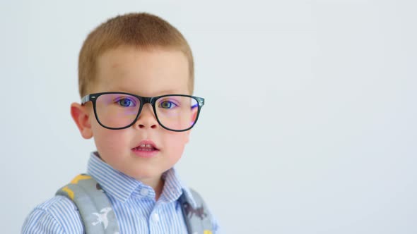 Little Boy Pupil in Glasses Backpack Blue Shirt Making Funny Face Grimaces