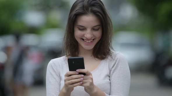 Young Happy Beautiful Woman Using Phone in the Streets Outdoors