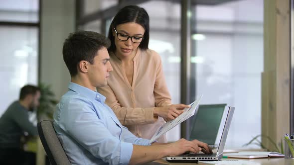 Colleagues Entering Data From Graphs Into Computer to Check Growth and Decline