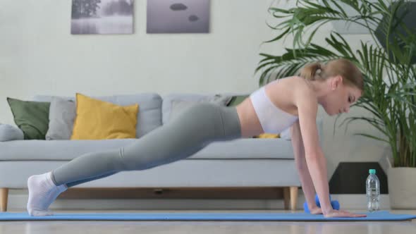 Hardworking Young Woman Doing Pushups on Yoga Mat at Home