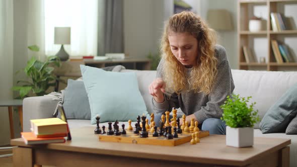 Pretty Young Woman Playing Chess Online Using Video Call