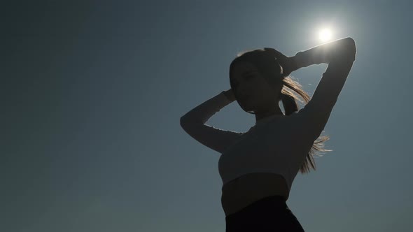 Slender Pretty Woman is Tying Ponytail From Her Hair