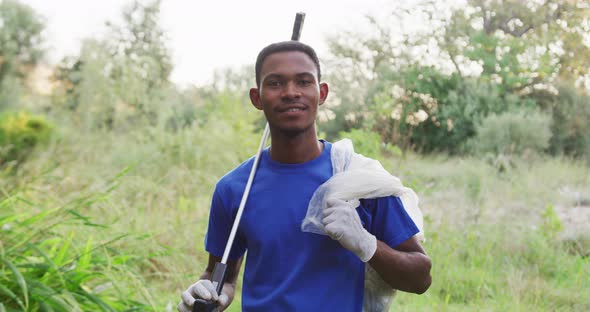 African American man smiling and looking at camera during river clean-up day