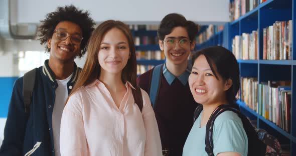 Portrait of Happy Multiethnic Young People Posing at Camera in School Library