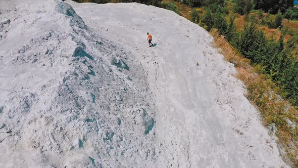 Sportsman in a white canyon exercising. Healthy athlete is running on the rocky hill