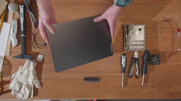 Repairman Examines a Laptop and Tries To Turn It on