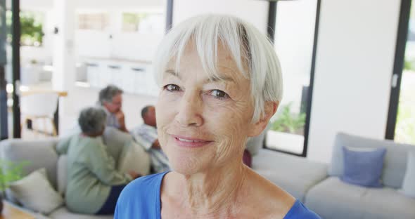 Portrait of happy senior caucasian woman with other seniors at retirement home