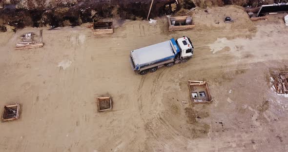 Truck Laden with Dirt and Soil Travels in a Road Construction Complex Site