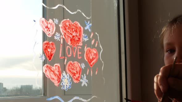 Child with father painting Love sign, playing indoors quarantine family leisure. Little girl holds