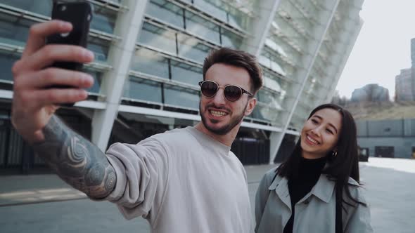 Beautiful Fashionable Couple is Making Picture While Walking Around the City