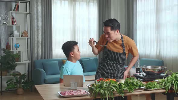 Asian Man Father And Little Child Son Cooking At Home, Food Tasting, Thumbs Up And Giving High Five