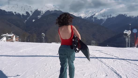 Portrait of Young Asian Woman in Red Swimsuit Run with Snowboard at Winter Ski Resort at Snowy Sunny