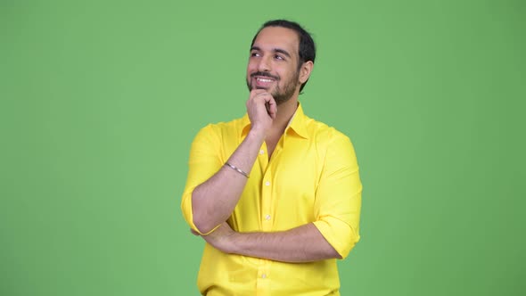 Young Happy Bearded Indian Businessman Thinking While Looking Up