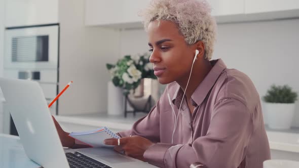 Young Happy African American Woman Watching Video Podcast or Movie in Laptop