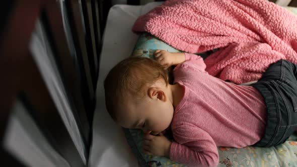 Baby girl sleeping on bed in bedroom