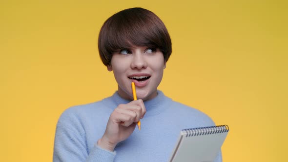 Young Woman Writing Down All Her Thoughts in Notebook