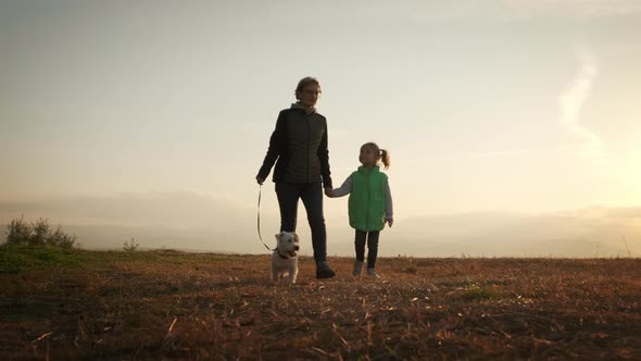 Woman with Little Daughter Walking the Dog in the Park Forest