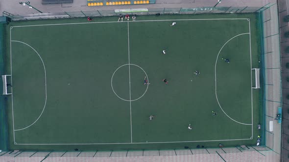 Players Play Football on a Green Football Field with White Markings