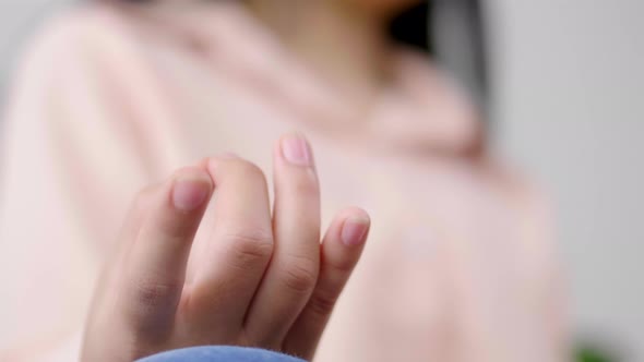 Close up hand of Asian woman doing meditation and sitting in lotus pose on couch