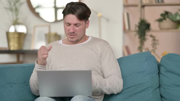 Middle Aged Man with Laptop Having Wrist Pain at Home