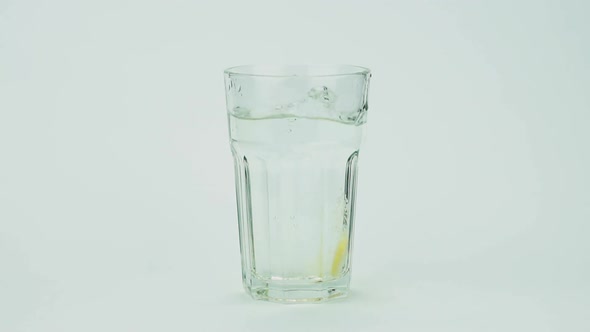 An Effervescent Pill Against Pain Falls Into a Glass and Dissolves Slow-motion Shot of Aspirin on a