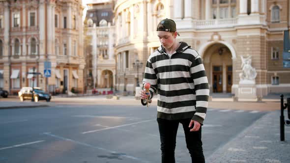 Young Teenage Boy Playing Kendama Outside in City Center During Sunset