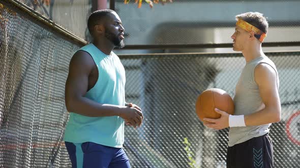 Basketball game partners communicating, man spinning ball on finger, friends