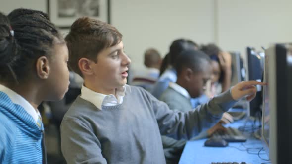 MS R/F Schoolboys and schoolgirls using computer and discussing in computer laboratory