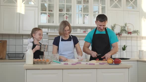 Happy Family of Three Cooking Together in Kitchen