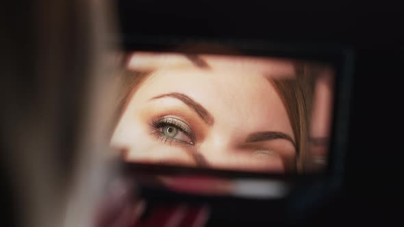 Reflection in Mirror of Womans Eyes with Shinning Makeup