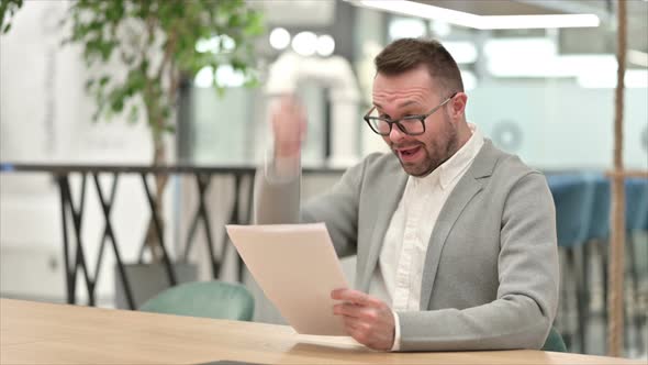 Creative Man Cheering After Reading Documents