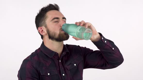 Attractive Man Enjoying Drinking Fresh Water From a Bottle