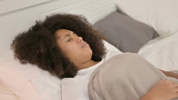 Young African Woman Waking Up From Nightmare in Bed