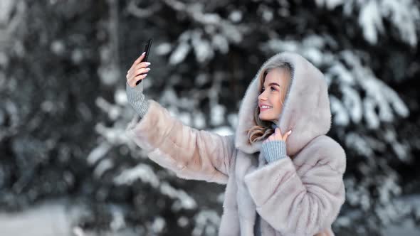 Woman in Fur Coat Taking Selfie at Winter Forest Use Smartphone