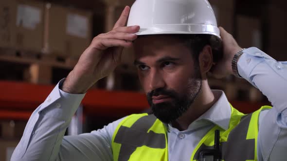 Confident Man Warehouse Worker Putting on Hard Hat